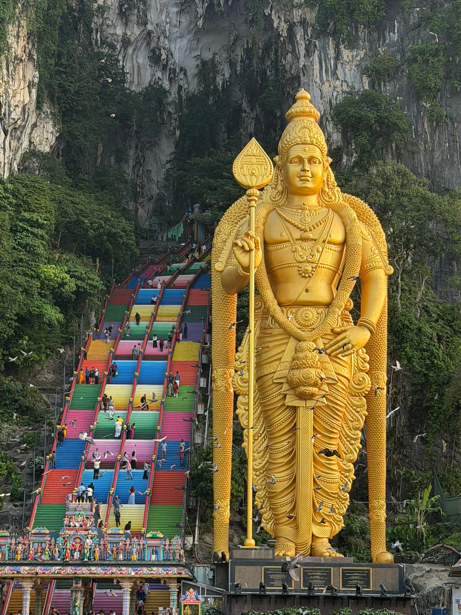 The golden Murugan statue beside the colorful Batu Caves staircase